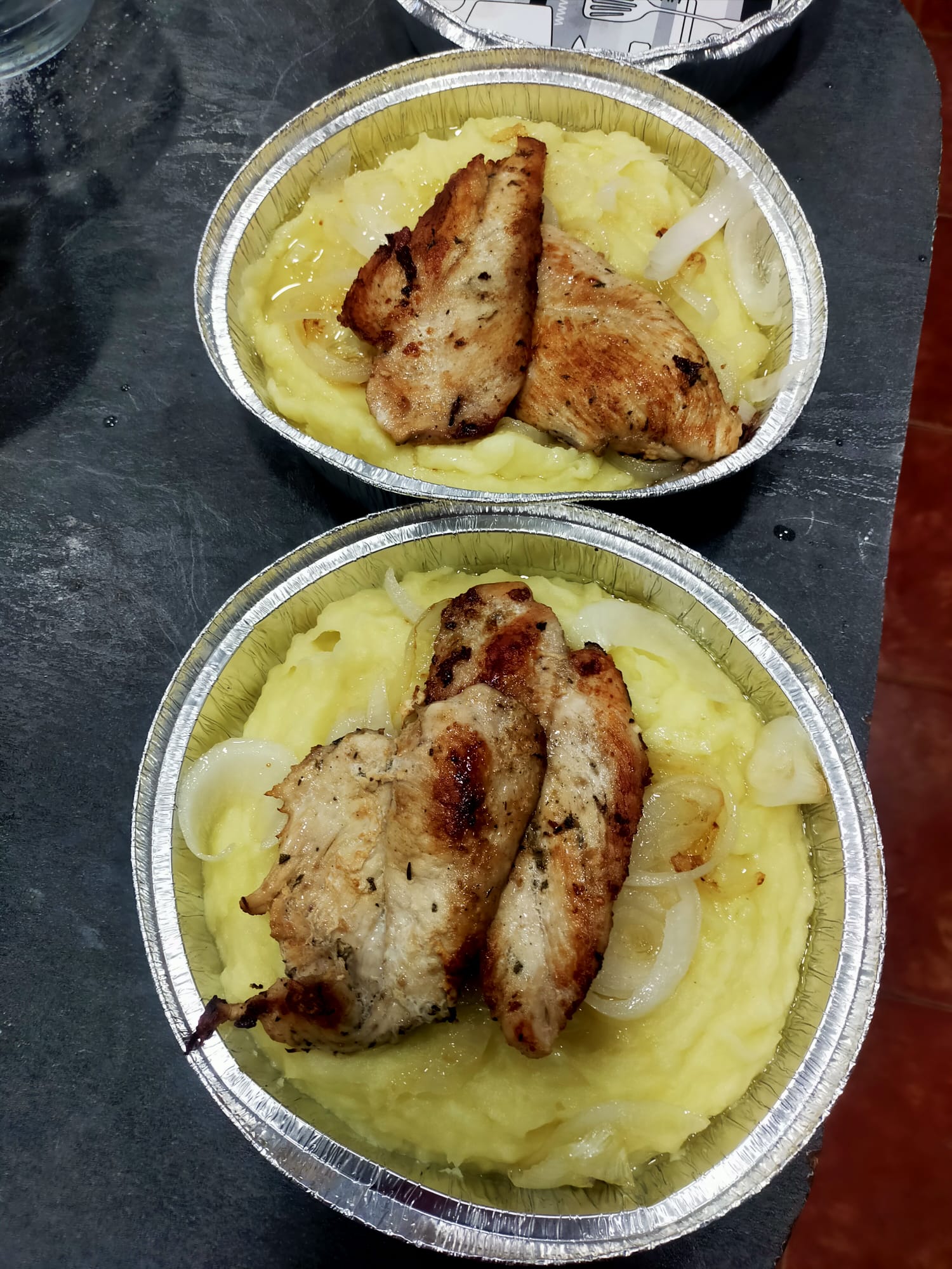 2 platos de puré de patatas con carne a la plancha y cebolla.